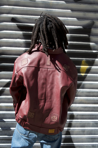 Person wearing a red leather jacket standing in front of a metal shutter.